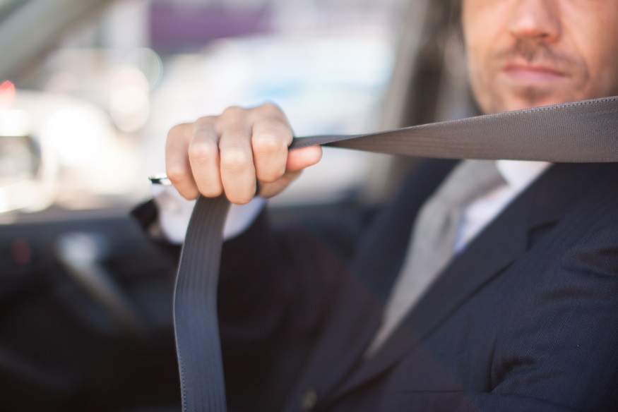 man fastens seat belt