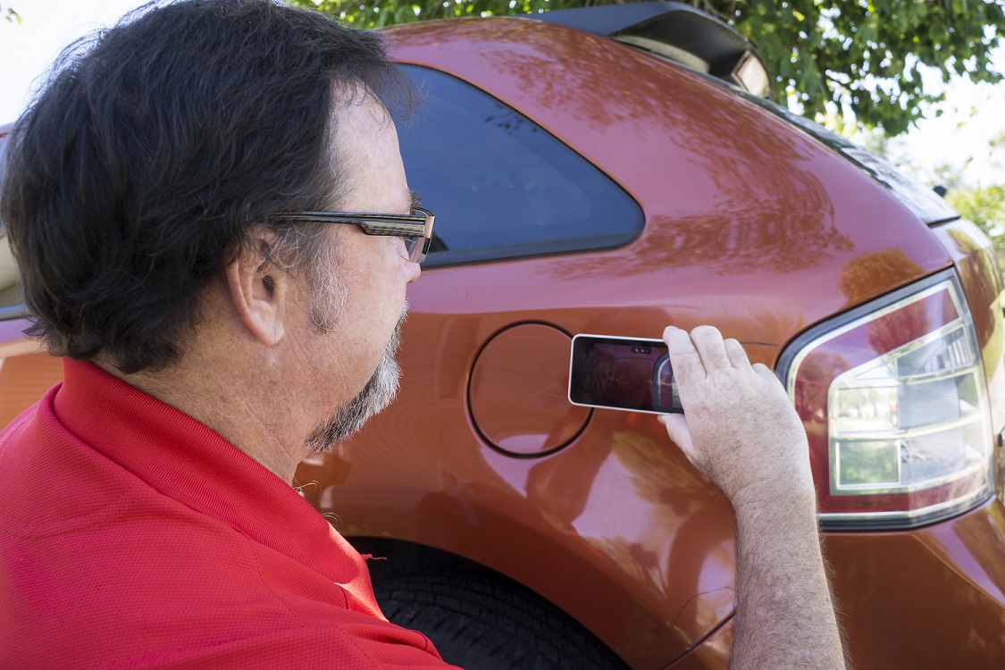 insurance adjuster takes photos of car