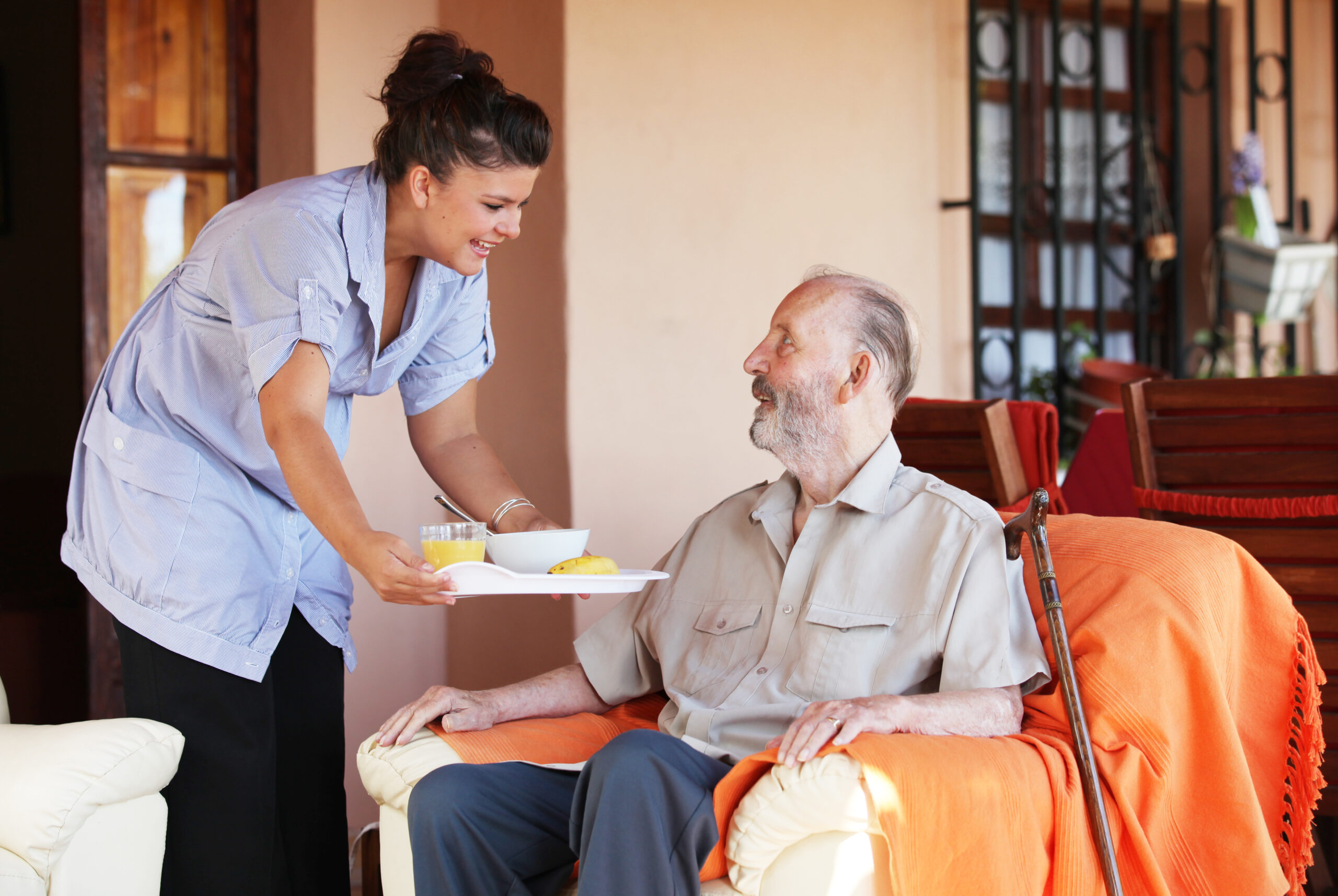 Elderly senior being brought meal by nurse
