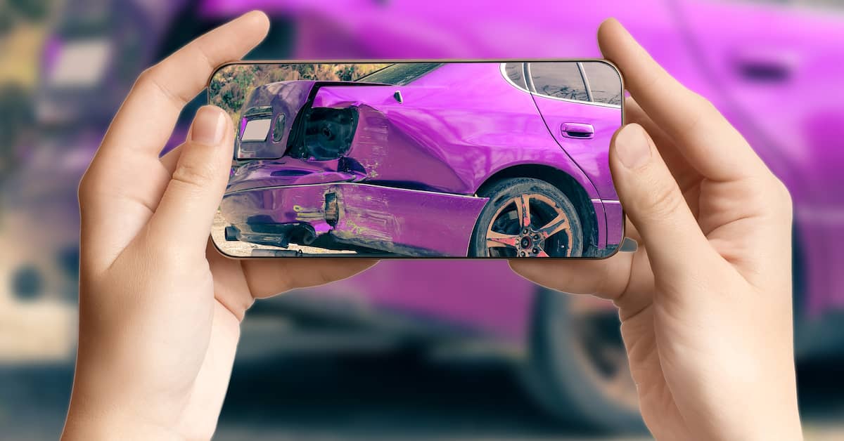 a person takes a picture of car damage with a cell phone | Boller and Vaughan