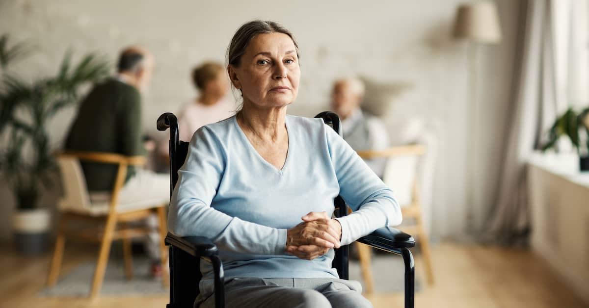 woman sits in wheelchair in a nursing home | Boller and Vaughan