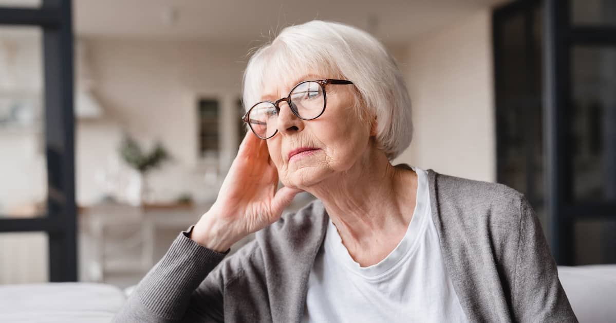 elderly woman holds head in hand | Boller and Vaughan