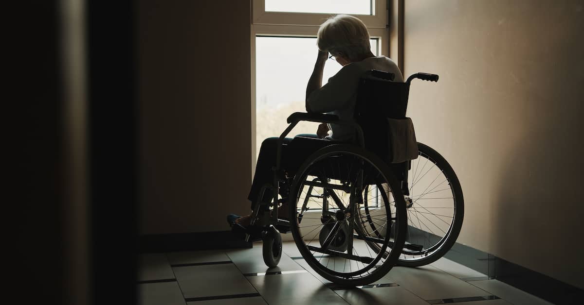 a woman in a wheelchair sits by a window | Boller and Vaughan